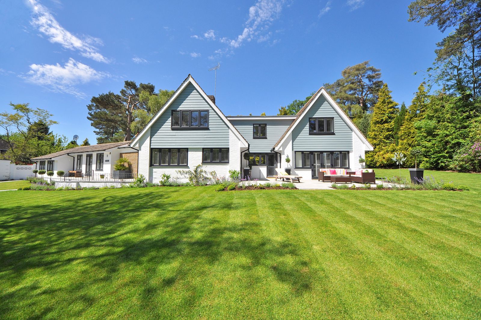 Farmhouse with a freshly striped, well-kept lawn